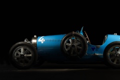 A blue vintage Bugatti 37a on a black background.